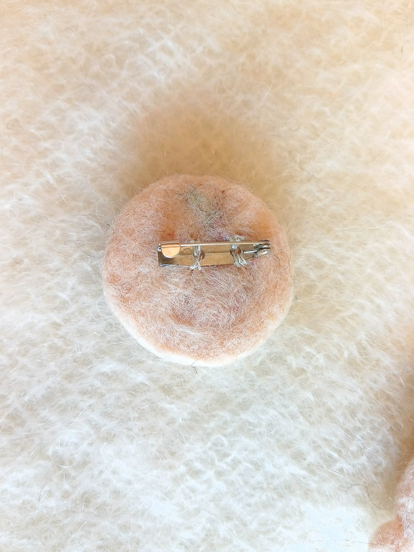 Back of needle felted brooch, with a steel c-clasp pin sewn with colour matched thread.