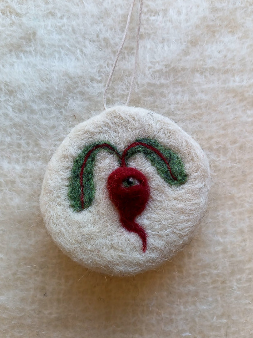 White needle felted ornament, featuring a red/purple beetroot with one eye and two floppy leaves. Handmade for medieval illustration lovers.