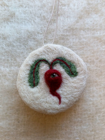 White needle felted ornament, featuring a red/purple beetroot with one eye and two floppy leaves. Handmade for medieval illustration lovers.