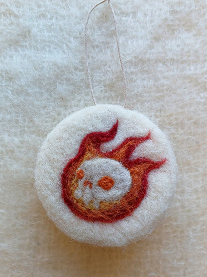 White felt ornament with red and orange flame design, featuring a burning white skull. White witch goth asethetic.