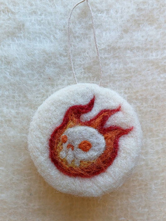 White felt ornament with red and orange flame design, featuring a burning white skull. White witch goth asethetic.