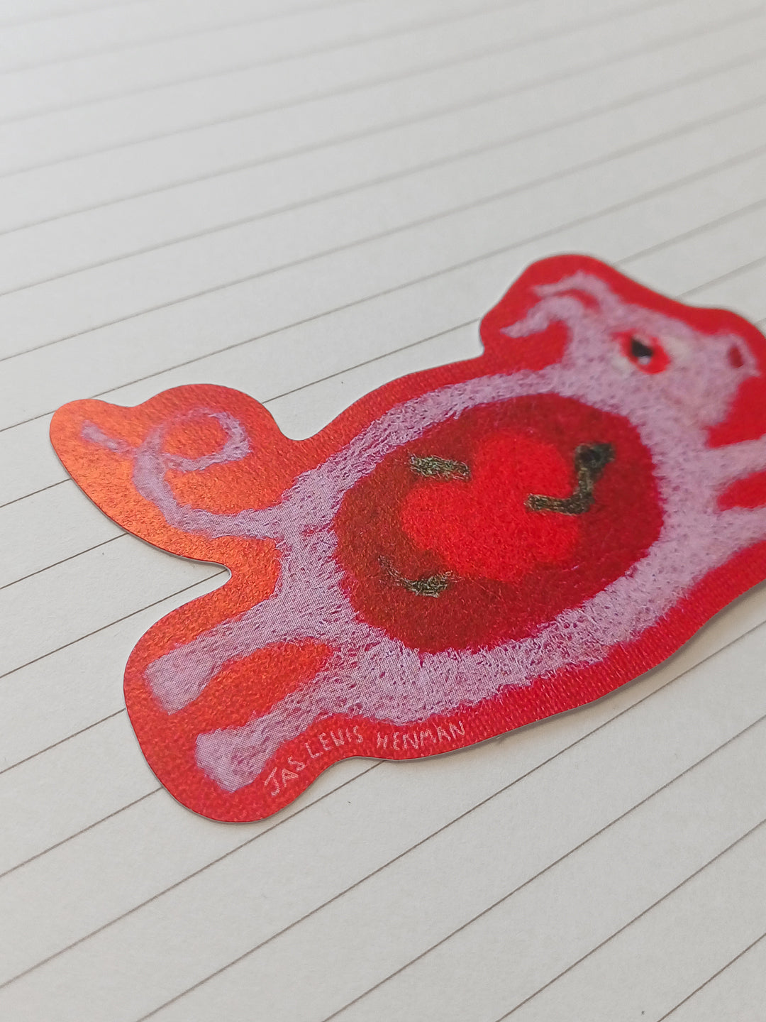 A close up of a die cut sticker featuring a read and pink leaping pig